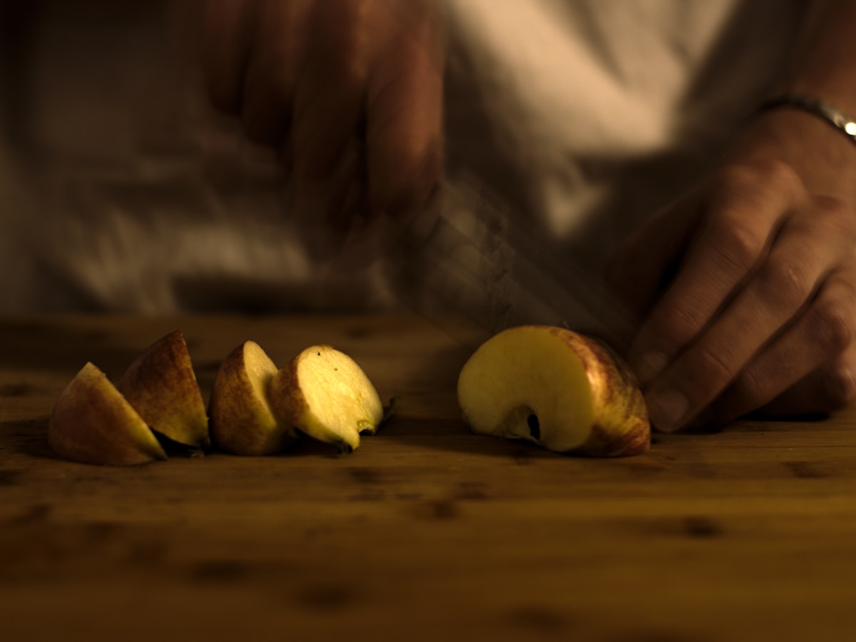 Fresh apple slices on a wooden cutting board prepared as dog treat portions